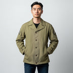 キャプテントムのSESSLER製M-41フィールドジャケット。カーキ色のコットン素材で三等軍曹のパッチ付き、ウォッシュ加工が施されたミリタリージャケットを着用した男性モデル。
